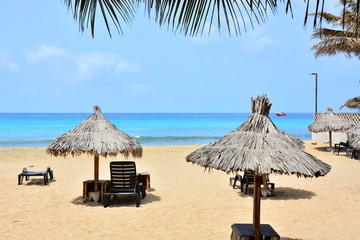 Sun umbrellas, beach umbrellas on a sandy beach and a blue, turquoise ocean, sea on Sal Island in...