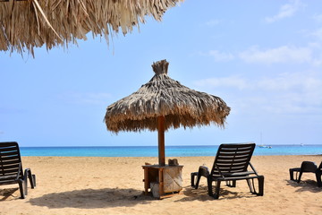 A sun umbrella, beach umbrella on a sandy beach and a blue, turquoise ocean, sea on Sal Island in Cape Verde, Cabo Verde