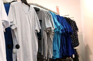 Men's t-shirts on hangers in a clothing store.