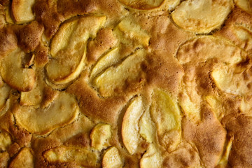 Apple pie, dessert from stewed fruits, closeup, texture, background, top view. Charlotte, homemade baking