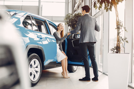 Couple buying the car. Pair in a car salon. Husband with vife choose the automobile
