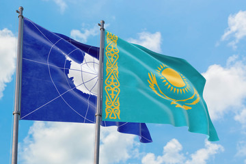 Kazakhstan and Antarctica flags waving in the wind against white cloudy blue sky together. Diplomacy concept, international relations.
