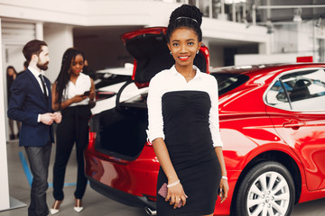 Woman buying the car. Lady in a car salon. Manager with a clients