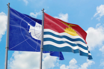 Kiribati and Antarctica flags waving in the wind against white cloudy blue sky together. Diplomacy concept, international relations.