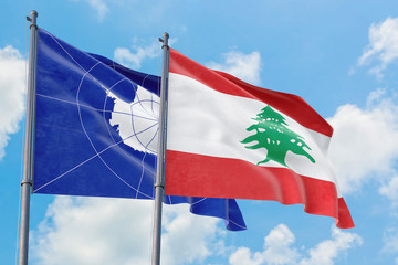 Lebanon and Antarctica flags waving in the wind against white cloudy blue sky together. Diplomacy concept, international relations.