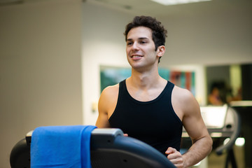 Fototapeta na wymiar Man running on the treadmill in a gym