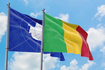 Mali and Antarctica flags waving in the wind against white cloudy blue sky together. Diplomacy concept, international relations.