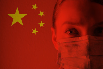 Girl in a mask against the background of the Chinese flag. Coronavirus, danger of disease, new...
