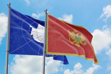 Montenegro and Antarctica flags waving in the wind against white cloudy blue sky together. Diplomacy concept, international relations.