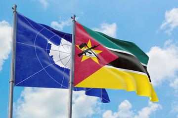 Mozambique and Antarctica flags waving in the wind against white cloudy blue sky together. Diplomacy concept, international relations.