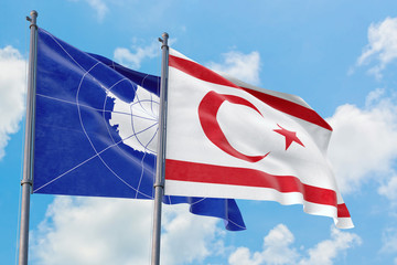 Northern Cyprus and Antarctica flags waving in the wind against white cloudy blue sky together. Diplomacy concept, international relations.