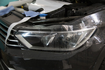 protecting the car with a protective film in the detailing studio