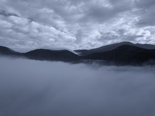 Aerial view of a mountain in the fog, Tuscany, Italy.