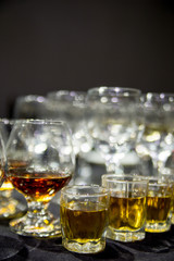 a glass of wine and a glass of whiskey stands on the table