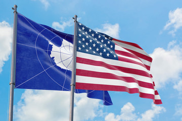 United States and Antarctica flags waving in the wind against white cloudy blue sky together. Diplomacy concept, international relations.