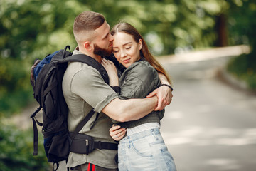 Couple in a forest. Man with a backpack. Woman in a green jacket