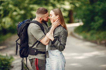 Fototapeta premium Couple in a forest. Man with a backpack. Woman in a green jacket