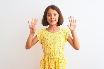 Young beautiful child girl wearing yellow floral dress standing over isolated white background showing and pointing up with fingers number nine while smiling confident and happy.