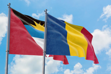 Chad and Antigua and Barbuda flags waving in the wind against white cloudy blue sky together. Diplomacy concept, international relations.