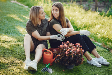 Family works in a garden. Ladies transplants vases