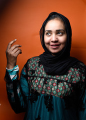 arabic woman with abaya dress shows of something raising up hand , Positive human emotion signs symbol, facial expression feelings  