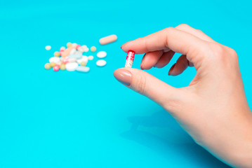 Pills in hands on a blue background.
