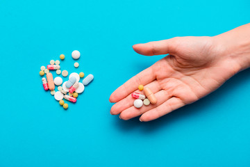 Pills in hands on a blue background.