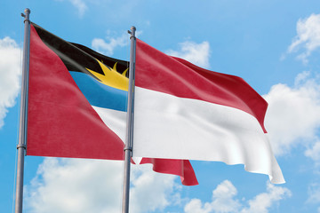 Fototapeta na wymiar Indonesia and Antigua and Barbuda flags waving in the wind against white cloudy blue sky together. Diplomacy concept, international relations.