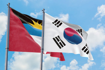 South Korea and Antigua and Barbuda flags waving in the wind against white cloudy blue sky together. Diplomacy concept, international relations.