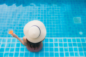 Portrait young asian woman relax happy smile around swimming pool in hotel