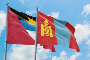 Mongolia and Antigua and Barbuda flags waving in the wind against white cloudy blue sky together. Diplomacy concept, international relations.