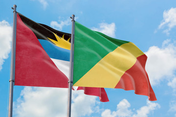 Republic Of The Congo and Antigua and Barbuda flags waving in the wind against white cloudy blue sky together. Diplomacy concept, international relations.
