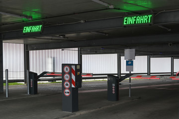 Multi-storey car park or parking garage with barriers and parking ticket automats, German labeled...