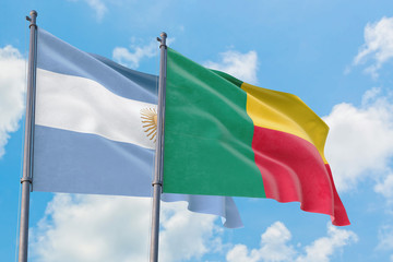 Benin and Argentina flags waving in the wind against white cloudy blue sky together. Diplomacy concept, international relations.