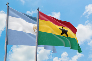 Ghana and Argentina flags waving in the wind against white cloudy blue sky together. Diplomacy concept, international relations.