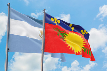 Guadeloupe and Argentina flags waving in the wind against white cloudy blue sky together. Diplomacy concept, international relations.