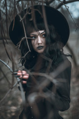 Young beautiful gothic enchantress in the forest