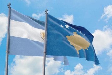 Kosovo and Argentina flags waving in the wind against white cloudy blue sky together. Diplomacy concept, international relations.