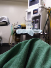 Floor of an equipped operating room. Anesthesia monitor and equipment. Blurry.