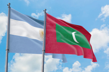 Maldives and Argentina flags waving in the wind against white cloudy blue sky together. Diplomacy concept, international relations.