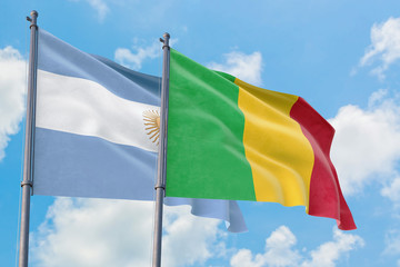 Mali and Argentina flags waving in the wind against white cloudy blue sky together. Diplomacy concept, international relations.