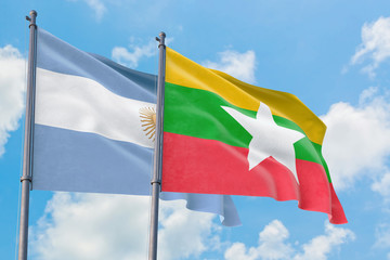 Myanmar and Argentina flags waving in the wind against white cloudy blue sky together. Diplomacy concept, international relations.