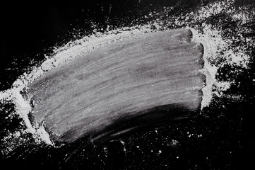 white ground smeared white powder on a black clean background, place for writing, top view, flat lay