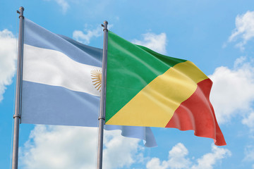 Republic Of The Congo and Argentina flags waving in the wind against white cloudy blue sky together. Diplomacy concept, international relations.