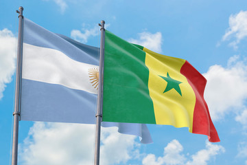 Senegal and Argentina flags waving in the wind against white cloudy blue sky together. Diplomacy concept, international relations.