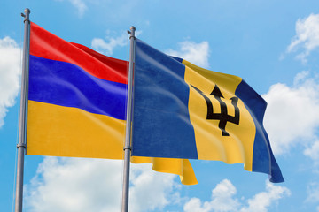 Barbados and Armenia flags waving in the wind against white cloudy blue sky together. Diplomacy concept, international relations.