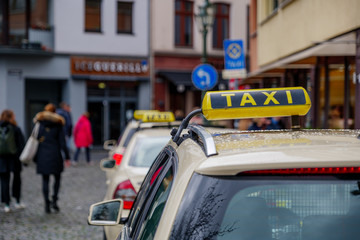 Selected focus at Taxi sign on roof of Taxi yellow cabs park at Carlsplatz in old town Düsseldorf,...