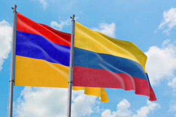 Fototapeta na wymiar Colombia and Armenia flags waving in the wind against white cloudy blue sky together. Diplomacy concept, international relations.