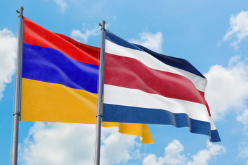 Fototapeta na wymiar Costa Rica and Armenia flags waving in the wind against white cloudy blue sky together. Diplomacy concept, international relations.