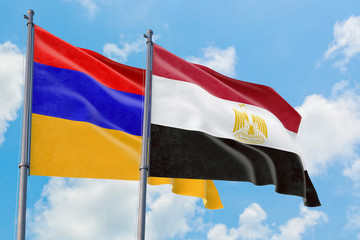 Fototapeta na wymiar Egypt and Armenia flags waving in the wind against white cloudy blue sky together. Diplomacy concept, international relations.